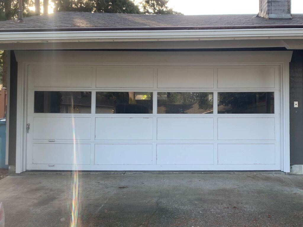 General Contracting job in Tumwater. garage door before. old dirty windows with no detailing