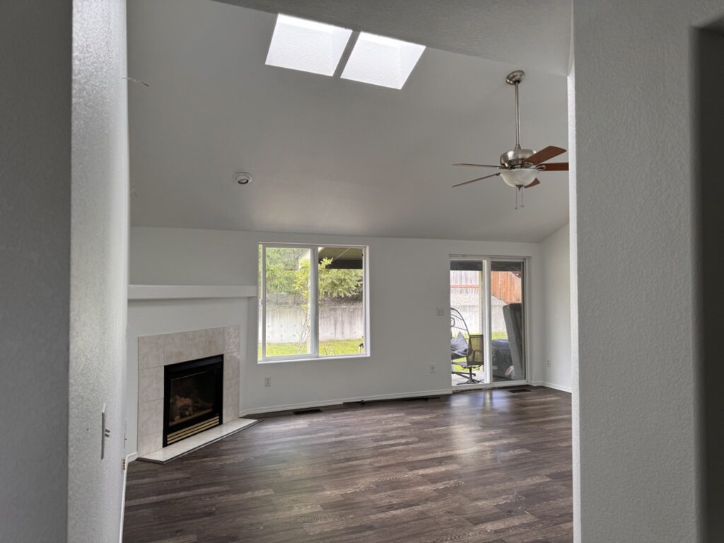 Fresh painted white walls, trim and ceiling. Flooring dark brown wood.